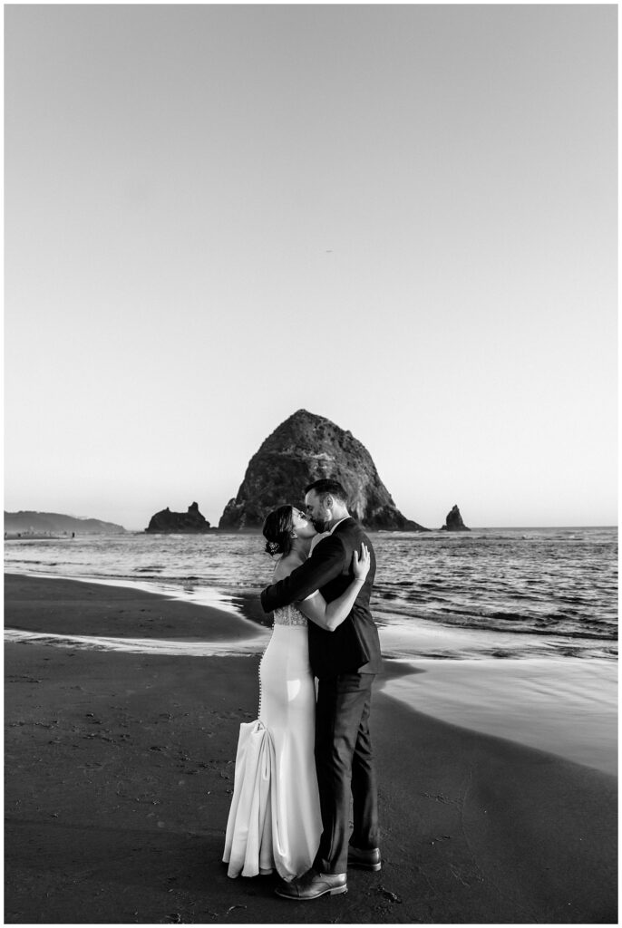Newlyweds kissing in front of Haystack rock during their Surfsand Resort Cannon Beach Micro Wedding on the Oregon Coast